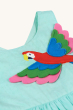 A closer look at the Macaw parrot applique on the chest of the Frugi Organic Phebe Party Dress - Spring Mint / Macaw. On a cream background