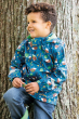 Boy leaning against a tree wearing the Frugi eco-friendly national trust colour puddle buster coat