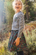 Girl stood in the woods wearing a striped top and the Frugi floral print maeve twill skirt