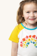 A closer look at the colourful rainbow flower blooms, and yellow sleeve on the Frugi Children's Organic Cotton Nyomi Raglan T-Shirt - Rainbow.