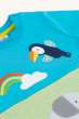 A closer look at the applique details of the Tucan, rainbow and elephant on the Frugi Children's Organic Cotton Little Penryn Panel T-Shirt - Elephant. Frugi Elephant Little Penryn Panel T-shirt is a light blue short-sleeve top with a green front panel an