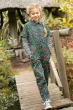 Girl walking across a wooden bridge wearing the Frugi organic cotton floral boiler suit