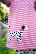 close up of a Child wearing the Frugi pink breton stripe dog Little Layla Dress