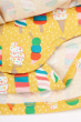 Close up of the bodysuit closure on the Frugi Dara Baby Body Dress with a yellow Rainbow Sprinkles design