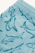 A closer look of the Jawsome shark print on the Frugi Children Organic Cotton Rocky Reversible Shorts - Stingray / Jawsome. A plain pale blue short with yellow drawstring on one side and a Jawsoms shark outline print on the reverse, on a cream background