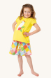 A child posing with their hands on their hips and smiling, wearing the Frugi Children's Organic Cotton Cassia Applique T-Shirt - Cockatoo, and flowery patchwork skirt