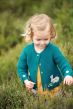 Toddler wearing the spruce moose applique rabbit cardigan with floral sleeve cuffs in tall grass