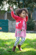 Child wearing the Frugi Watermelon pink dog Character Cardigan with a matching breton dress and norah tights 