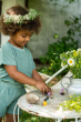 Close up of child playing with the eco-friendly Grapat baby nin toys on a white table next to a metal jug of flowers