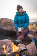 An adult sat outside by a fire, holding the Klean Kanteen 12oz Insulated Mug in White