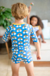 View of child from behind wearing the Maxomorra Rainbow Swim Top with matching swim trunks