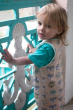 Little boy holding onto some blue railings wearing the Meyadey kids eco-friendly city bee dungarees