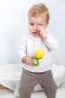 A child holding onto a Oli & Carol Lemon Rattle Teether 
