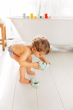 Child playing with the Oli & Carol Flo The Floatie Mint colour duck bath toys in a bathroom