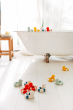 Oli & Carol Flo The Floatie Duck bath toys in various colours pictured in a bathroom