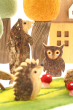 Close up of the Papoose natural wooden owl and bear toy figures in front of a Papoose autumn tree