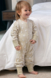toddler wearing cotton tail footless onesie with a white rabbit all-over print on pale cream and stretchy cream cuffs from piccalilly