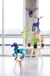 Studio roof eco-friendly slotting animal totem models stood on some wooden furniture next to some potted plants in front of a bright window