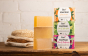 Bio-d natural plum and mulberry solid soap bar, mandarin soap bar, lime and aloe vera soap bars next to soap boxes, on a wooden table in front of wash cloths and sponge