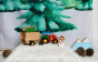 Close up of the Wondercloth Christmas Tree Play Cloth in a snowy play scene with the Bajo wooden tractor and Lanka Kade Christmas figures.