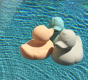 Three Oli & Carol Elvis The Duck Bath Toys floating in a swimming pool 