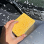 Close up of hand cleaning a car with the A Slice of Green plastic-free cellulose sponge