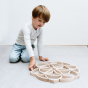 Boy playing with the 36 Abel mini wooden blocks toy set on a white background