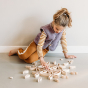 Girl sat on the floor playing with the Abel curved Golden Ratio toy blocks