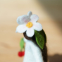 A close up of the flower details on the head of the Ambrosius felted cherry girl figure