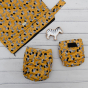 Baba + Boo zebra print flatlay with newborn and one-size nappy, zebra lanka kade toy and a wet bag