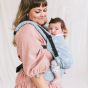 A woman carries a child on her chest wearing a Tula - Harbor Skies - Free To Grow - Baby Carrier.