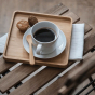 Bambu Bamboo Teaspoon pictured on a saucer with a cup of cofee