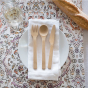Bambu Knife, Fork & Spoon Set pictured on a cotton napkin on a patterned tablecloth