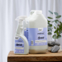 bio-D Bathroom Cleaner 500ml spray bottle and 5 Litre bottle on a wooden table, with a white background and green plant
