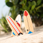 Three unique magnetic wooden surfboard toys on the beach.