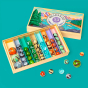 Billes & Co kids recycled glass Mountain Trip marble set open on a teal background with some coloured marbles scattered in front of the box