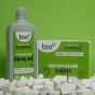 Box of Bio D eco friendly dishwasher tablets and bottle of Bio-D rinse aid on a green background, and bio-D dishwashing tablets in front