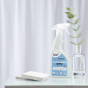 Bio-D natural eco friendly streak free glass and mirror cleaner in a 500ml spray bottle on a white background next to a green plant in a small glass bottle