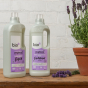 Bio D eco-friendly vegan lavender laundry liquid 1L bottle and conditioner 1 Litre bottle on a white brick back ground, with purple lavender next to the products