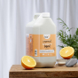 Bio-D natural mandarin eco-friendly 5 litre washing up liquid on a wooden table with a white back ground and green plant