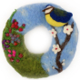 A close up of a completed The Makerss - Blossom and Blue Tit Wreath Needle Felt Kit. A beautifully decorated wreath with a colourful Blue Tit stood on a cherry blossom tree, and a grassy section with lots of colourful flowers