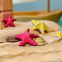 Bumbu Wooden Red Starfish Set posed in a beach scene.