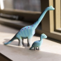 Bumbu Big Wooden Brontosaurus pictured next to the baby brontosaurus on a window sill 