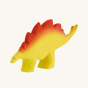 Bumbu wooden Stegosaurus dinosaur figure, beautifully hand painted with yellow body and red back scales, on a cream background