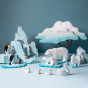 Bumbu plastic-free wooden polar bears, penguins and swans laid out on a light blue background in front of some Bumbu Waldorf icy rocks and white Maple tree toys 