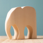 Bumbu Wooden Elephant - Paint Your Own. The toy sits on a wooden surface against a blue background.