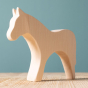 Bumbu Wooden Horse - Paint Your Own. The toy sits on a wooden surface against a blue background.