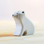 Bumbu eco-friendly small sitting wooden polar bear toy figure on a light wooden work top in front of a white background
