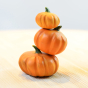 3 Bumbu handmade plastic free pumpkin toys stacked on a light wooden worktop in front of a white background
