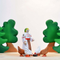 Bumbu plastic free wooden hen toy figures stood in a circle next to a wooden woman figure on a beige worktop